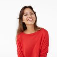 Joy and happiness concept. Picture of stunning Hispanic student girl with brown loose hair grinning broadly, feeling happy and carefree after she passed all exams and now enjoying leisure time